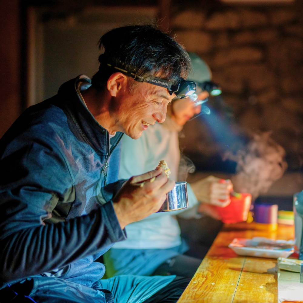 Man eating with Ledlenser HF6R Core headtorch in use