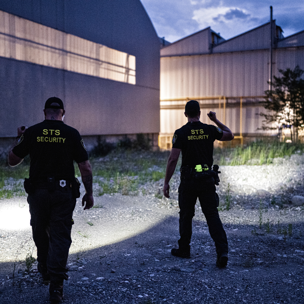 Two security personnel from Security walking in an industrial area.